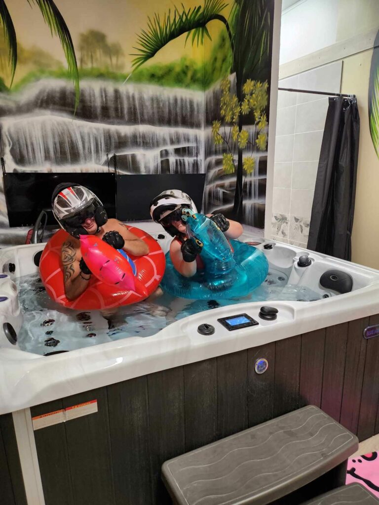 Personne déguisées avec un casque de moto et deux bouées bleu et rouge s'amusant dans notre jacuzzi - Sauna et jacuzzi près de Dieppe.